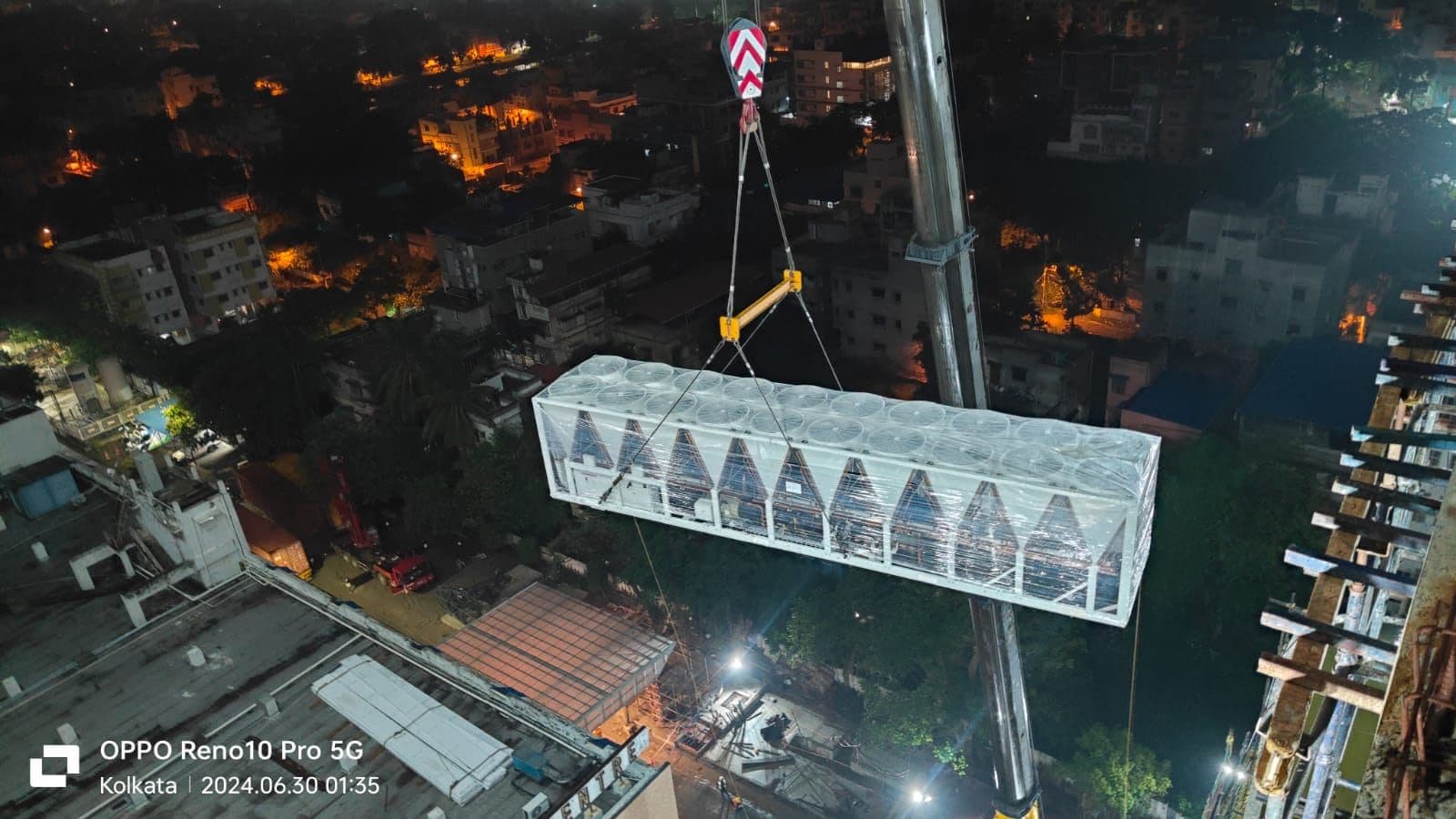 Chiller suspended from a mobile crane above Peerless Hospital, Kolkata, at night